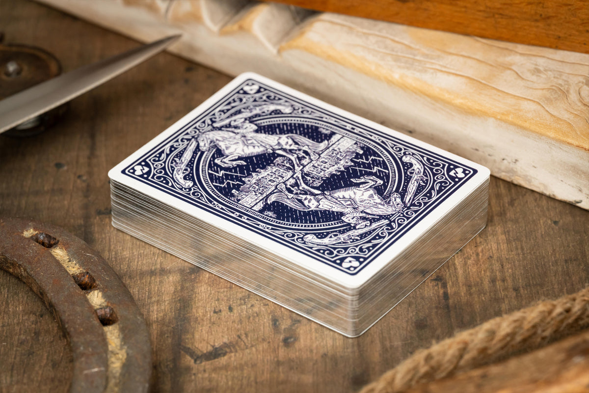 Stack of luxury gilded playing cards with intricate design on a wooden surface