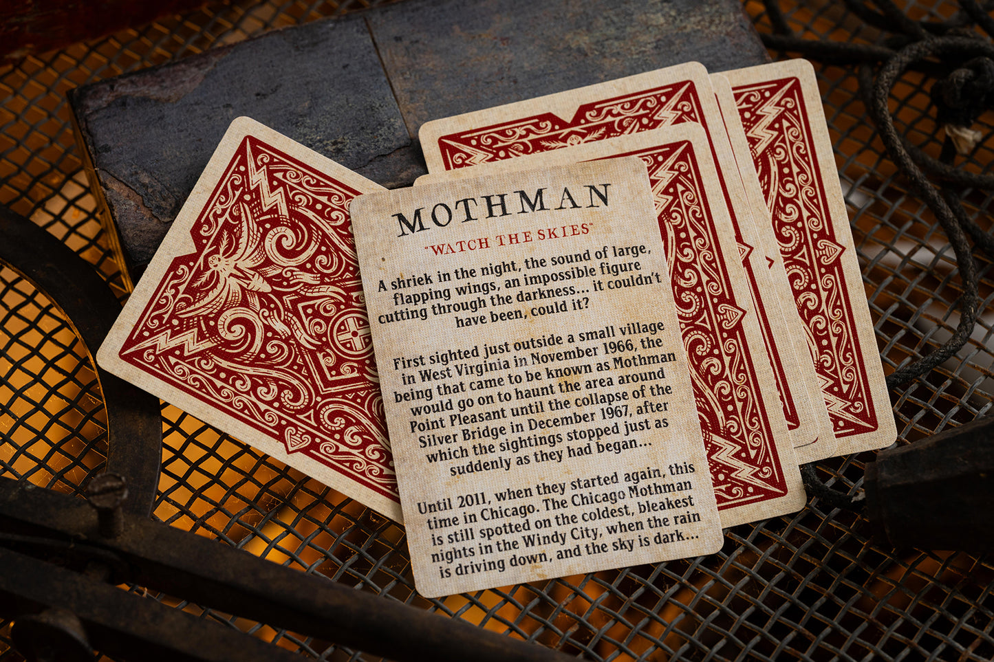 Playing cards featuring Mothman on a textured surface