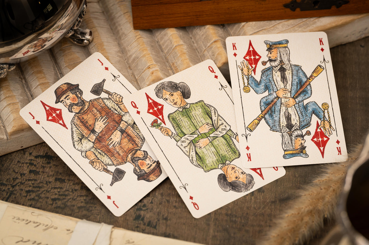 Vintage Love & Retribution illustrated character courts playing cards with intricate designs on a textured surface