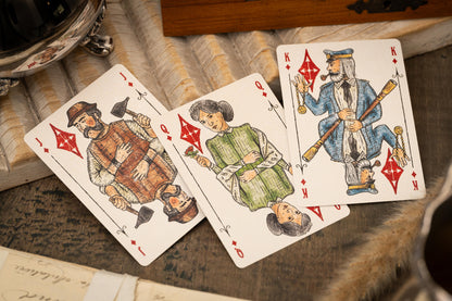 Vintage Love & Retribution illustrated character courts playing cards with intricate designs on a textured surface