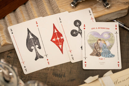 Four playing cards with unique designs on a wooden surface - Love & Retribution Ace of HEarts