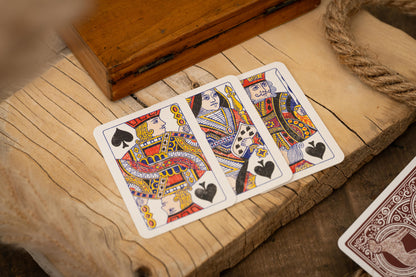 Three playing cards featuring queens on a wooden surface with a rustic background.
