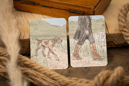 Two cards with illustrations of a dog and a person on a wooden surface with rope.