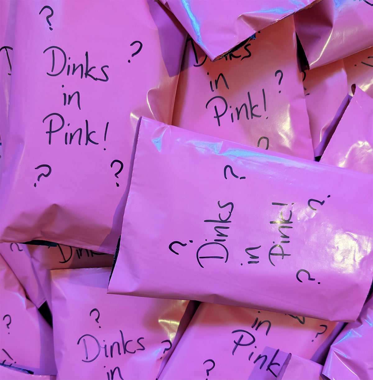 lightly damaged decks of premium playing cards in bright pink packaging