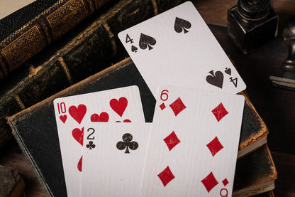 Playing cards with red and black suits on a wooden surface