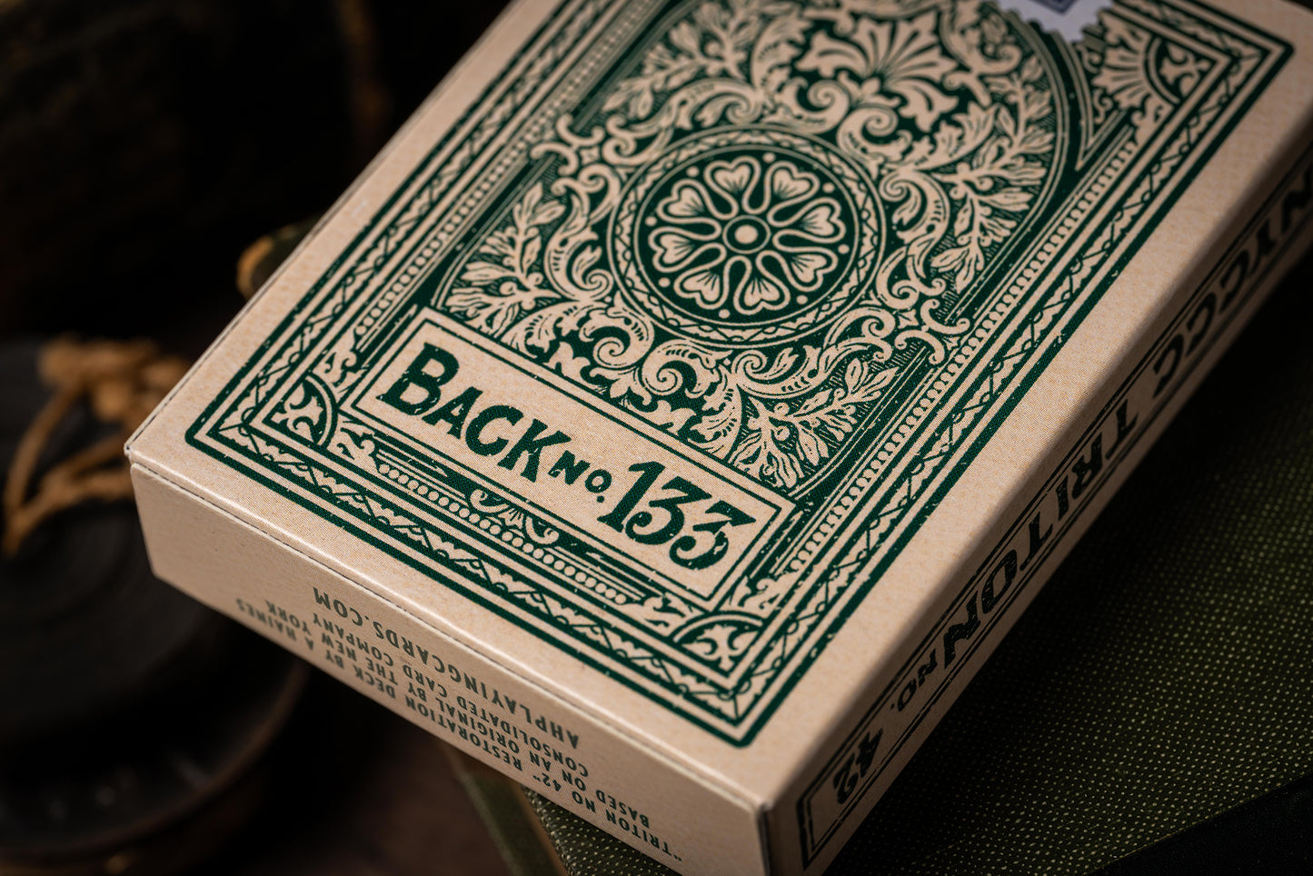 Close-up of a deck of playing cards with decorative green design on the back