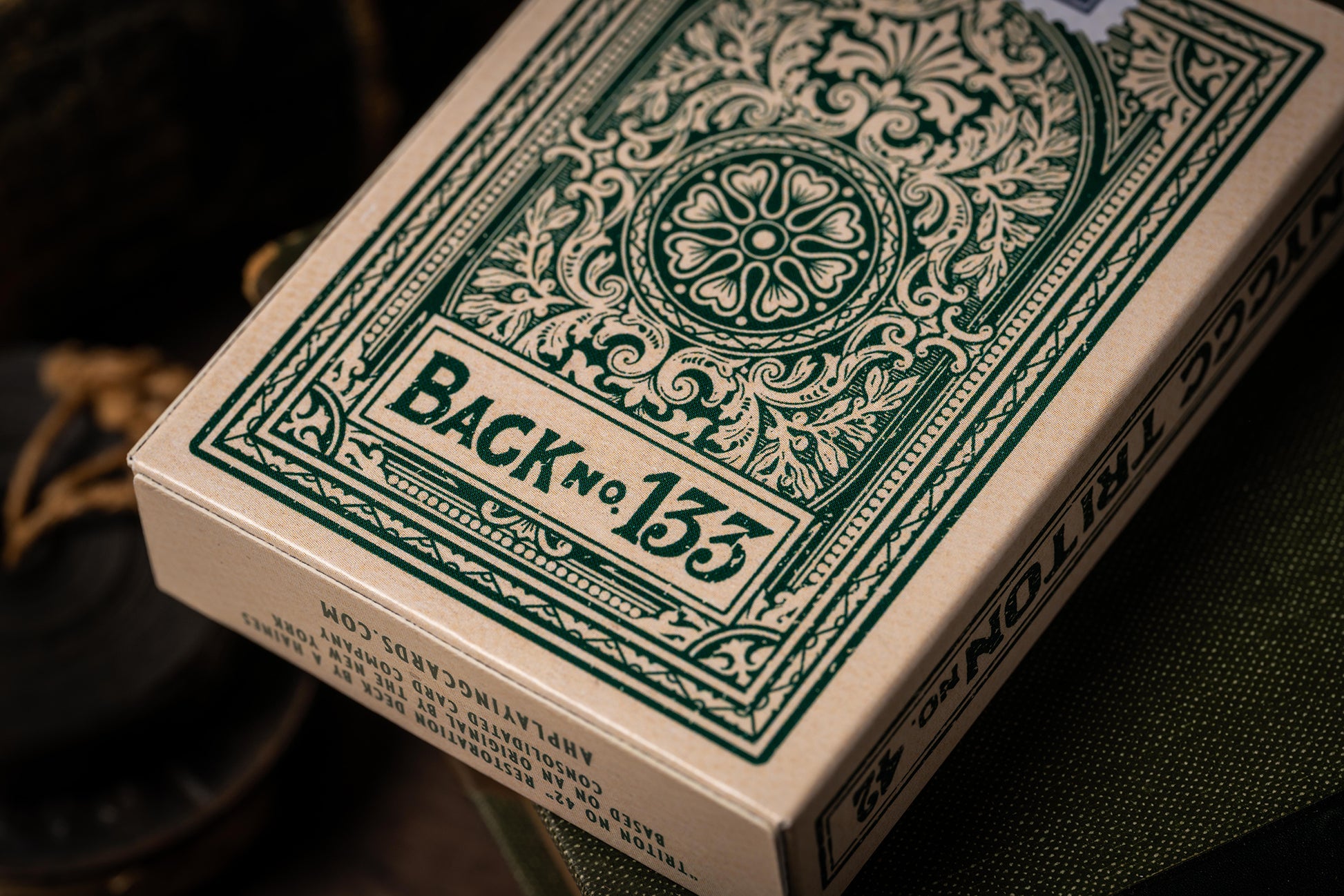 Close-up of a deck of playing cards with decorative green design on the back