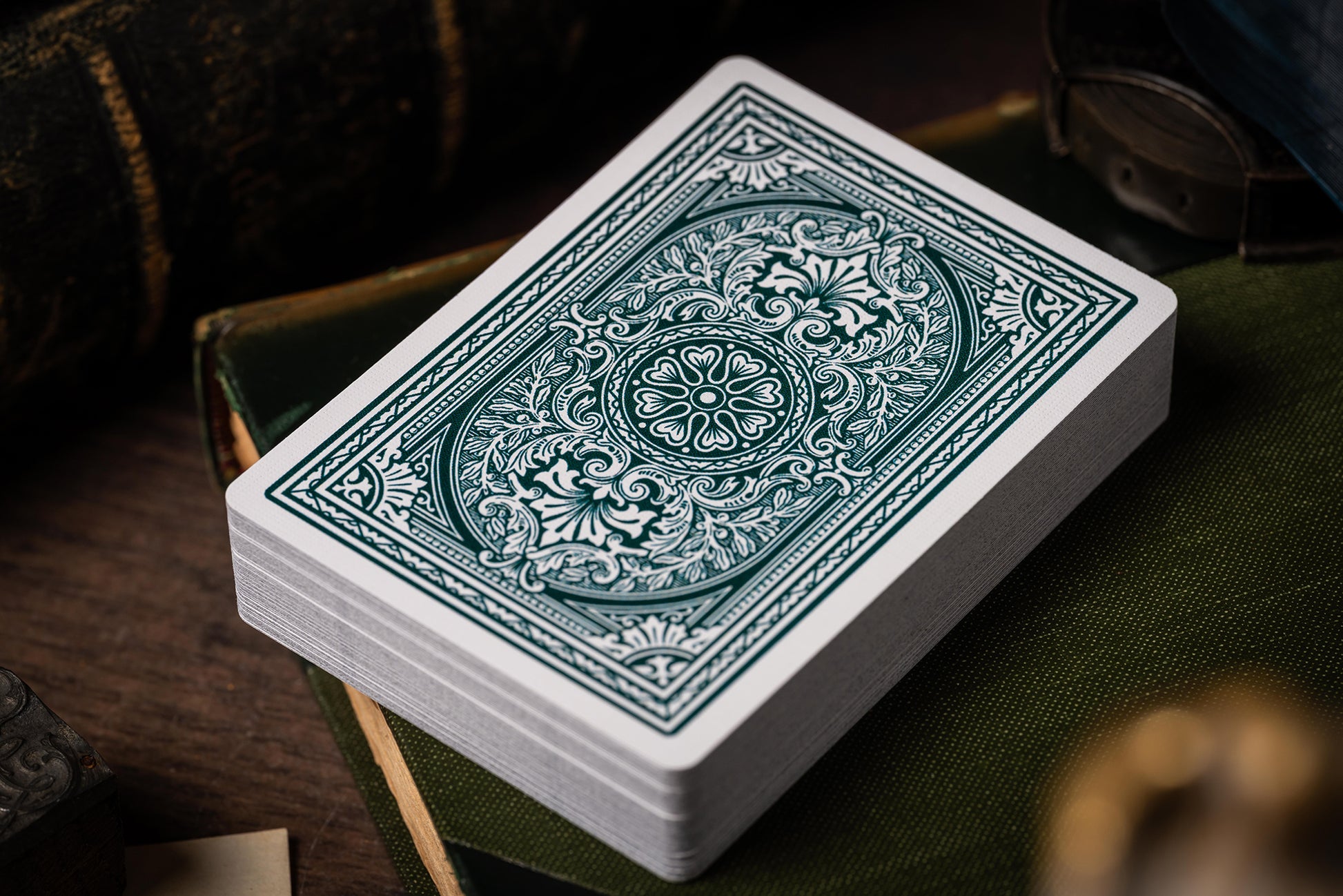 Stack of classic vintage playing cards with decorative green design on a wooden surface