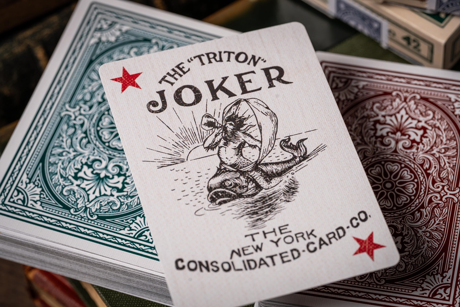 vintage Playing card with 'The Triton Joker' design and text, featuring a red star and black illustration.