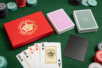 crown series poker pvc casino playing cards in luxury foiled gift box - with poker chips - top view on gaming table with plastic cut card and ace of spades