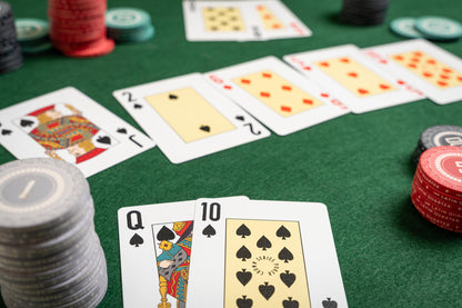 Poker playing cards and chips on a green felt table