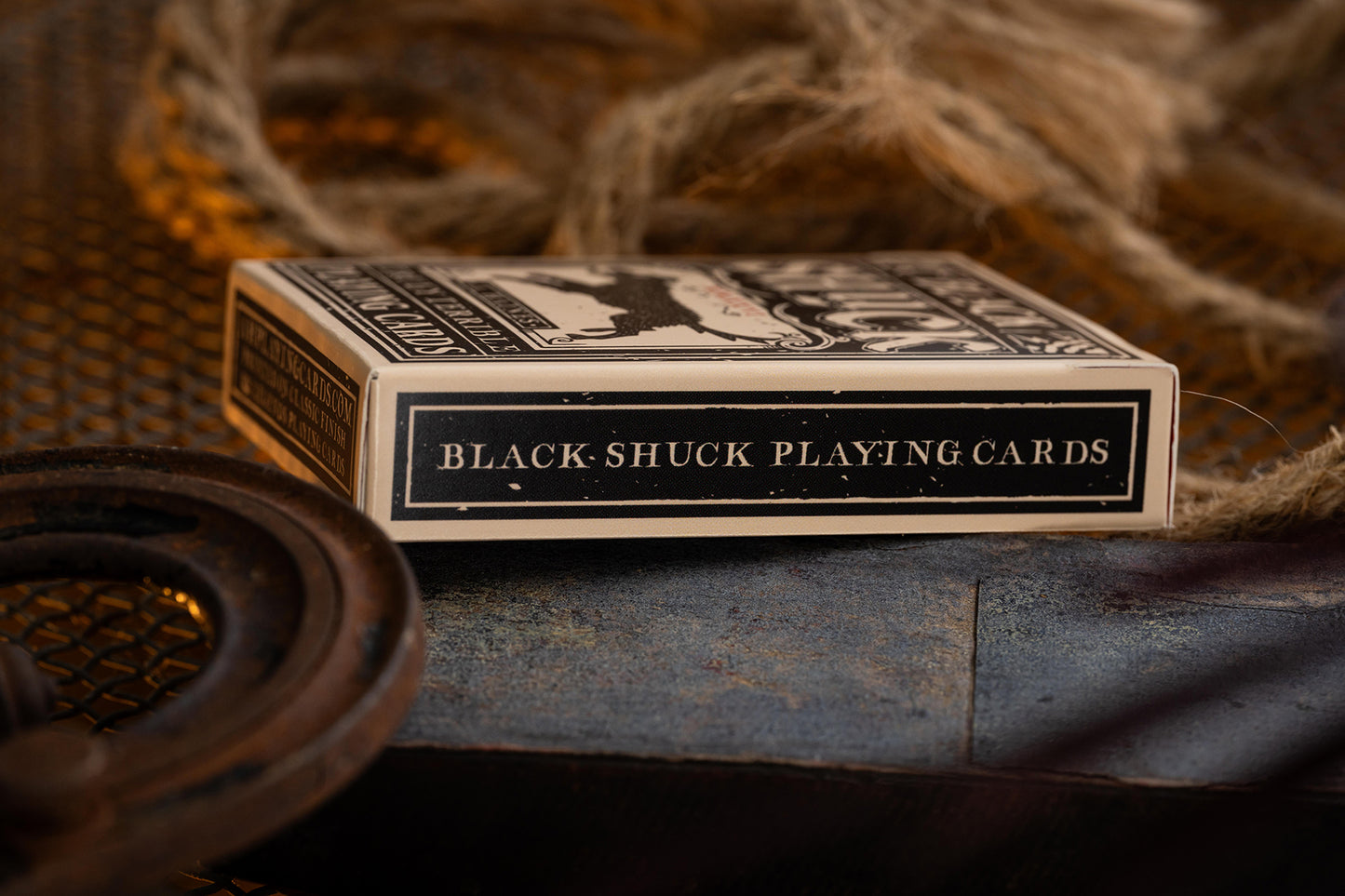 Black-Shuck playing cards on a rustic background with rope and metal objects.