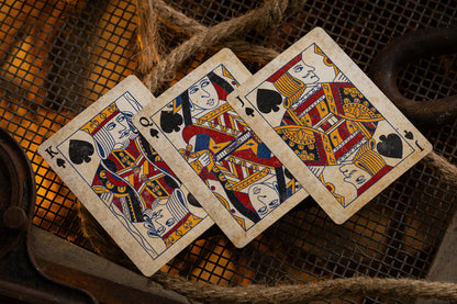 Three vintage courts playing cards on a textured surface.