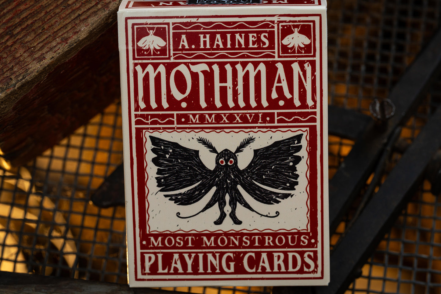 premium playing card tuckbox with Mothman design and text on a textured background - uk playing cards - hand-drawn