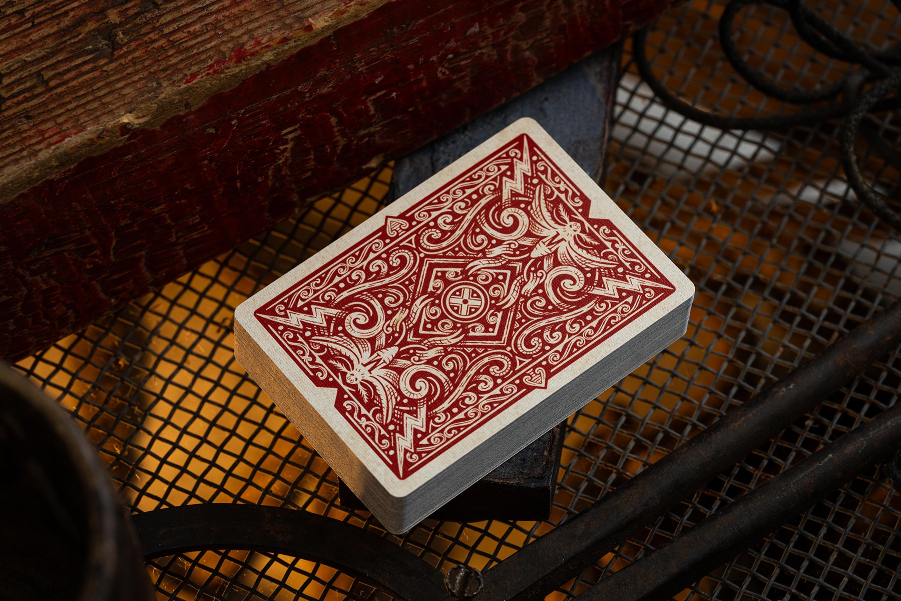 Playing card with red and white design on a textured surface