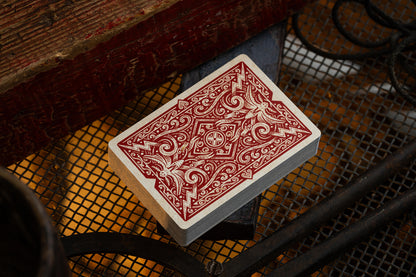 Playing card with red and white design on a textured surface