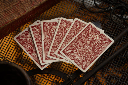 Four red vintage british cryptids playing cards on a textured surface