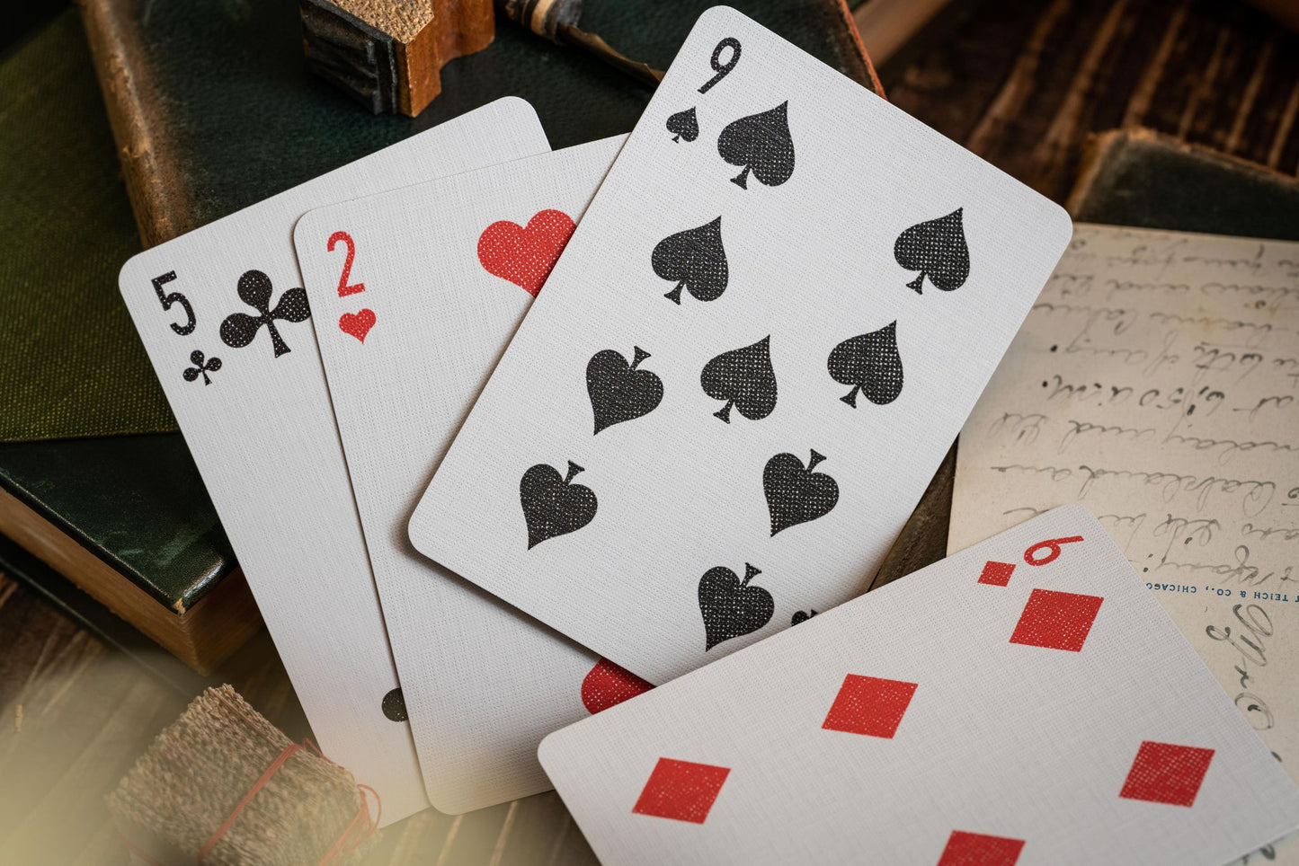 Imported Playing Cards. Image shows, from left to right, 5 of Clubs, 2 of Hearts, 9 of Clubs and 6 of Diamonds. All hand drawn pips.