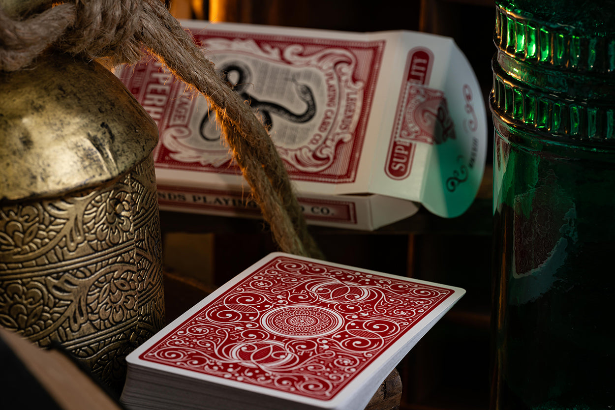 Red classic playing cards with intricate designs on a dark background