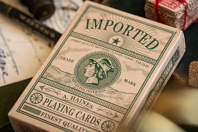 Imported Playing Cards. Close up shot of vintage style deck of cards. Background image contains old stamps, books and postcard